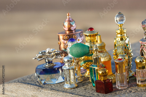 Oriental parfumes in golden bottles stand on the table