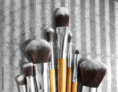 Set of makeup brushes on silver tray