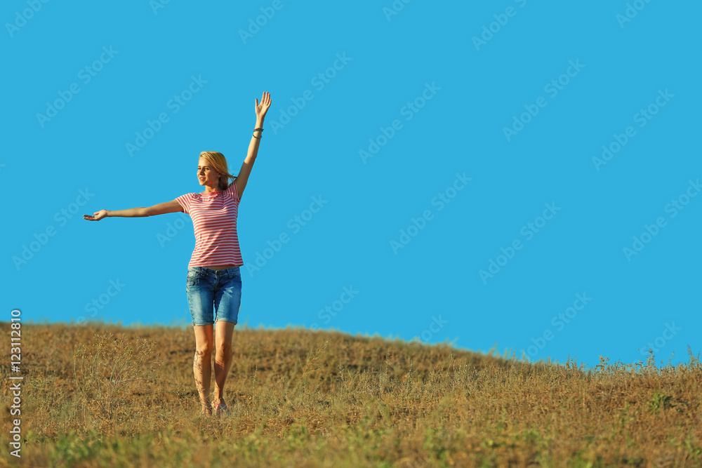 Happy young woman on blue sky background Happy young woman on blue sky background