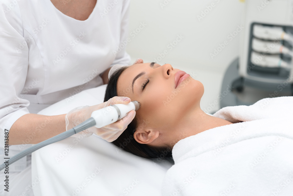 Young woman getting cavitation skin care treatment Young woman getting cavitation skin care treatment