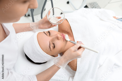 Professional beautician making facial treatment photo