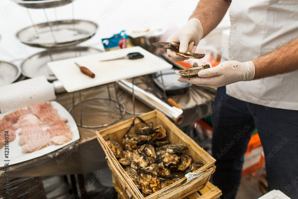 Cook cleans mussel standing on the kitchen Cook cleans mussel standing on the kitchen