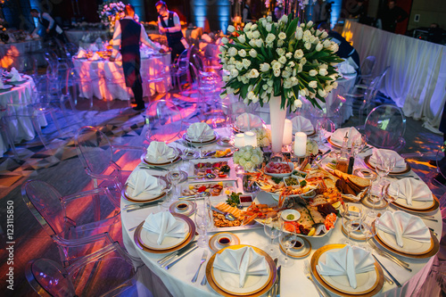 Round dinner tables served with white crockery and salted appeti