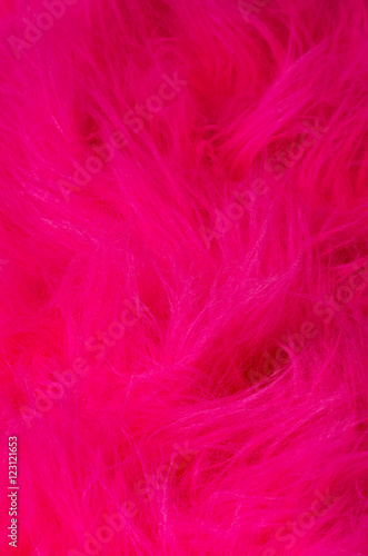 Pink plush fabric vertical. Very soft polyester textile made of synthetic fibers with long hairs. Macro close up material photography.