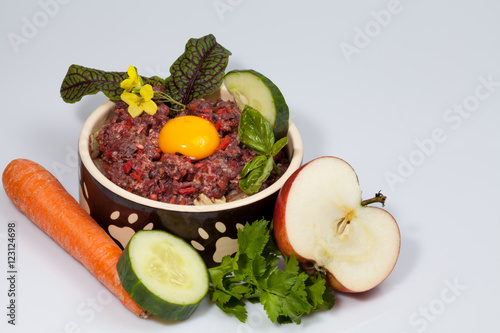 Fototapeta Naklejka Na Ścianę i Meble -  Futternapf mit Barf auf weißem Hintergrund mit viel Textfreiraum, Makro horizontal