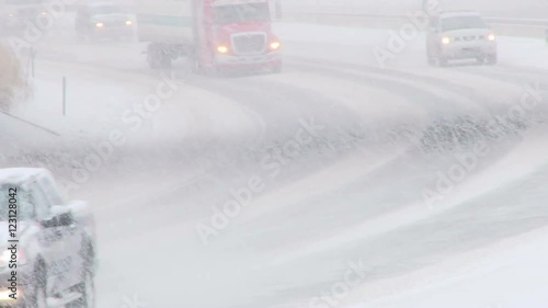 Traffic driving along freeway during intense snow storm.