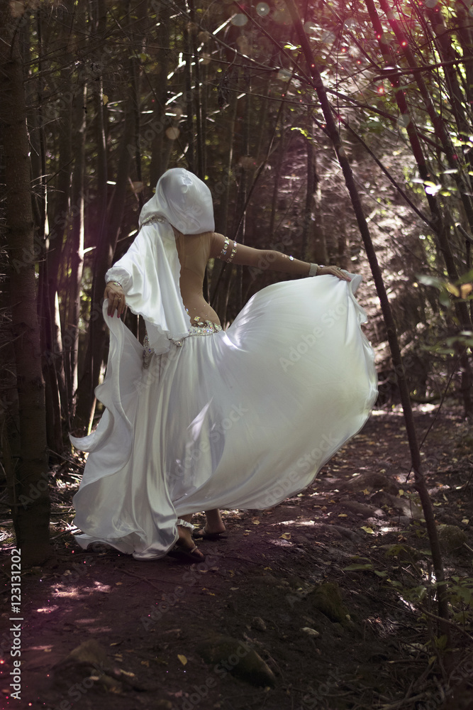 Beautiful magician in mysterious dark forest. Magical atmosphere. Fairytale Beautiful magician in mysterious dark forest. Magical atmosphere. Fairytale
