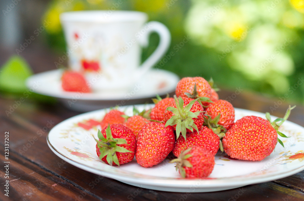 Mature, appetizing strawberries scattered on the white plate. Mature, appetizing strawberries scattered on the white plate.