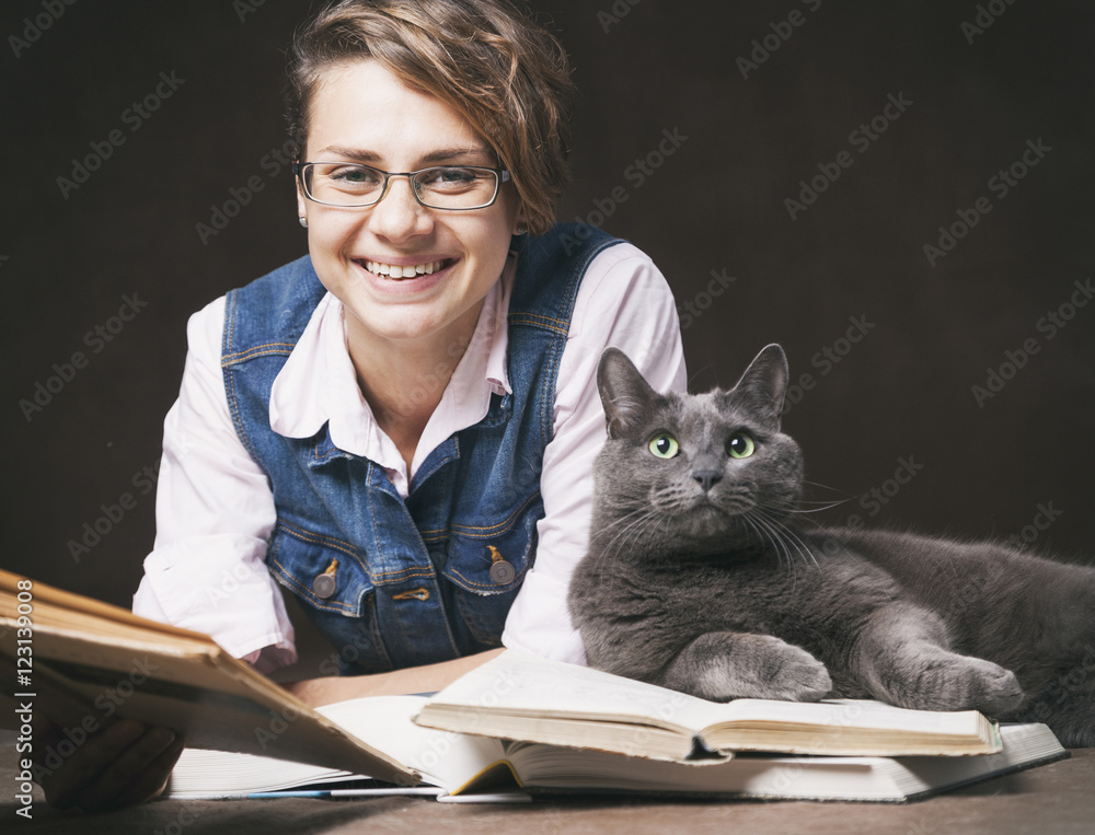 young woman in glasses with a book and a cat