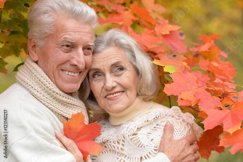 Beautiful happy middle-aged couple in the autumn park