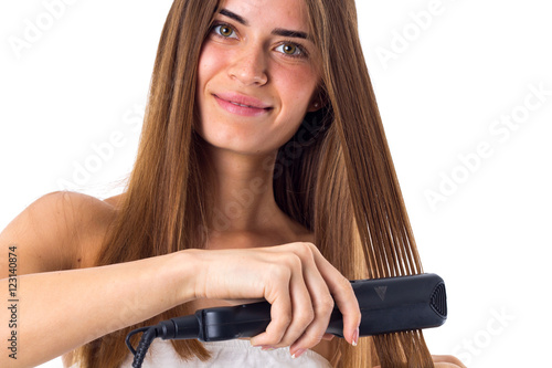Woman using hair straightener 