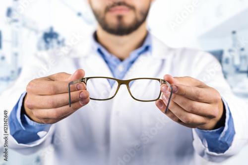 eyesight care concept - optician giving new optical glasses