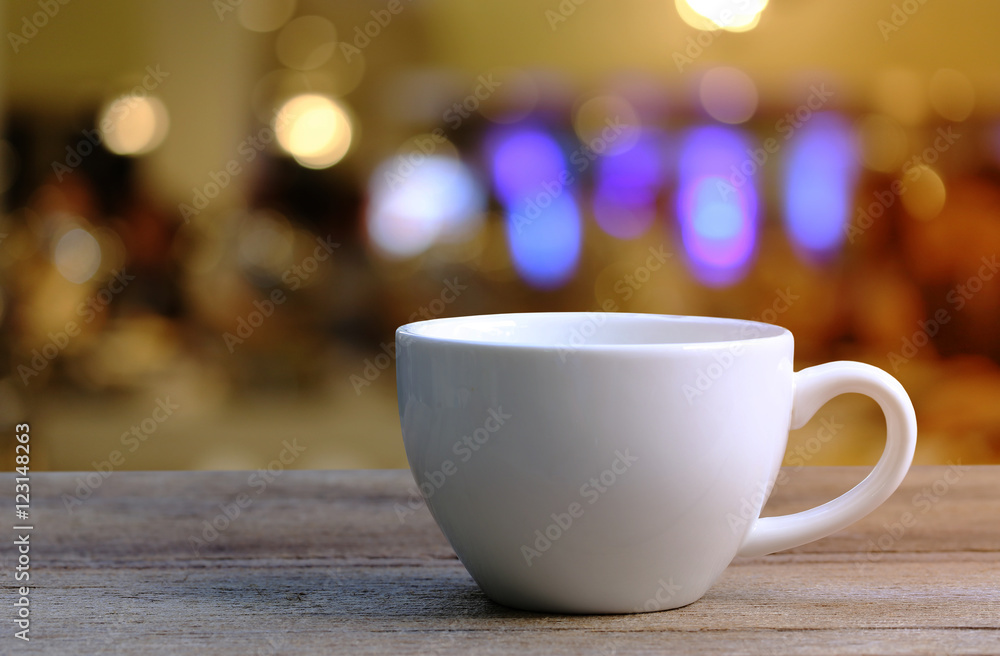 White Coffee cup on wooden table in coffee shop blur background. White Coffee cup on wooden table in coffee shop blur background.