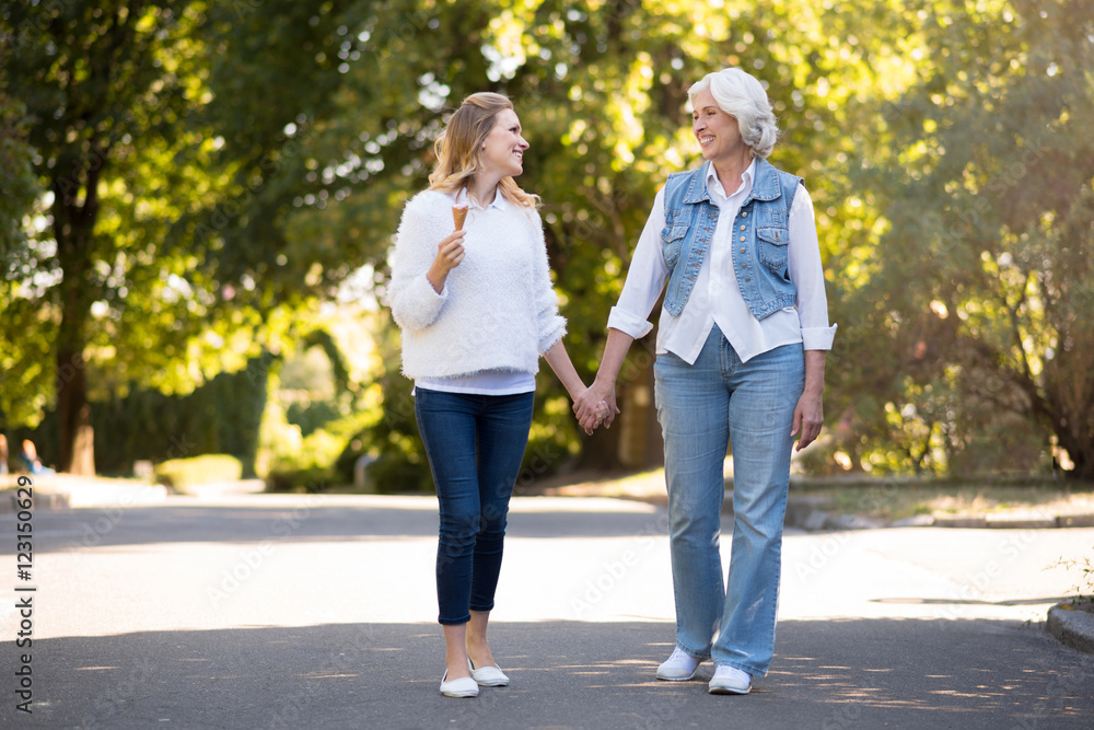 Two delighted pretty women walking in the park. Two delighted pretty women walking in the park.