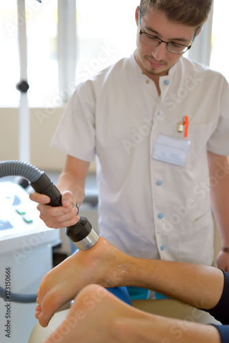 Physiotherapist performs ultrasound therapy treatment