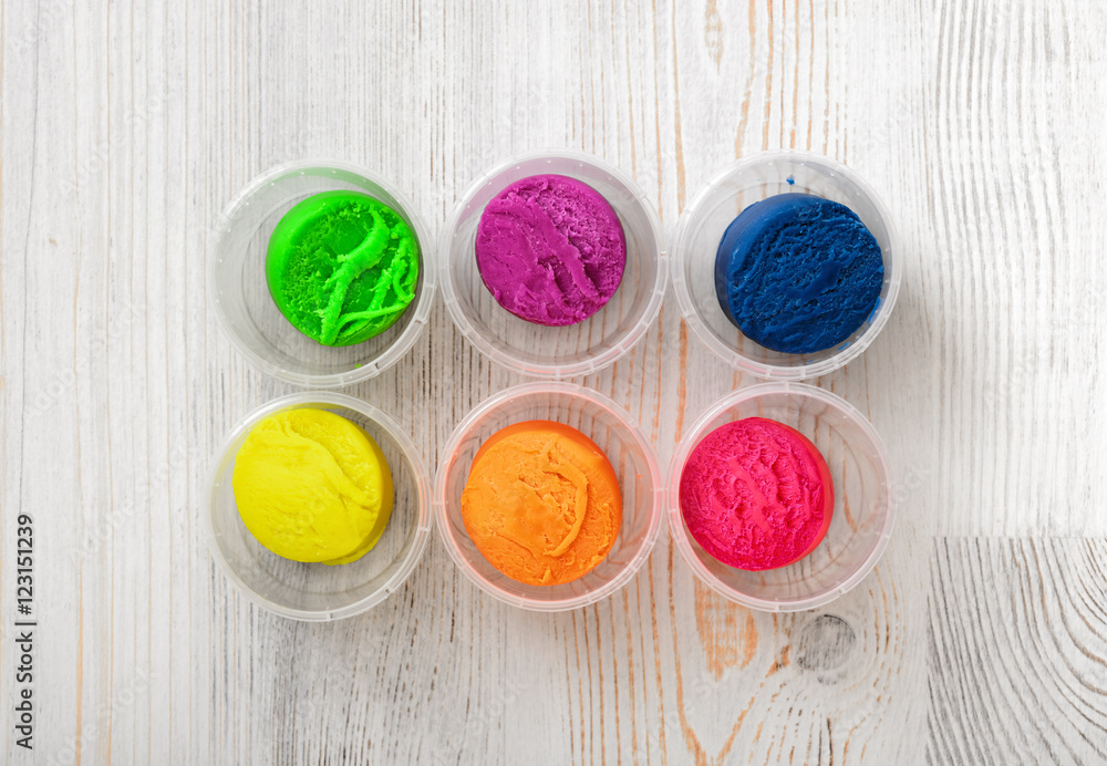 Still life photo of six small plastic boxes with multicolor plasticine Still life photo of six small plastic boxes with multicolor plasticine