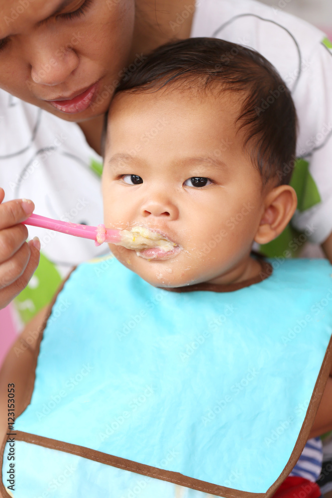 Asian baby boy to eating food in concept of health foods and nut Asian baby boy to eating food in concept of health foods and nut