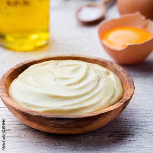 Homemade mayonnaise  mayo in a wooden bowl. White background.