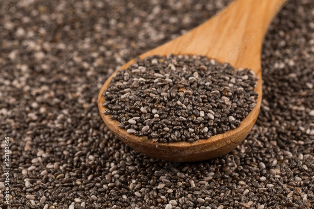 Chia seeds in wooden spoon Chia seeds in wooden spoon