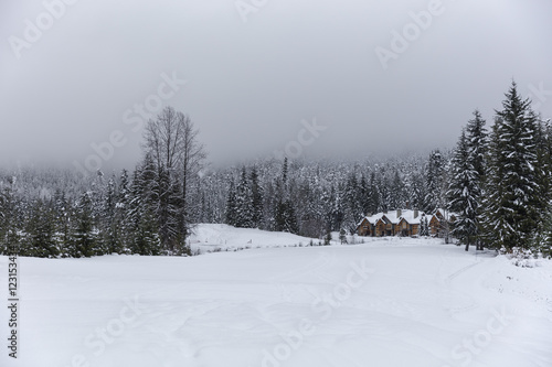 Snow covered mountain in Whistler British Columbia, Canada. Winter wonderland in the Pacific North West. Winter cabin covered in snow with forest and mountain background. 