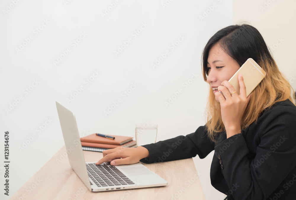 young business woman sitting at workplace and telephone conversa young business woman sitting at workplace and telephone conversa