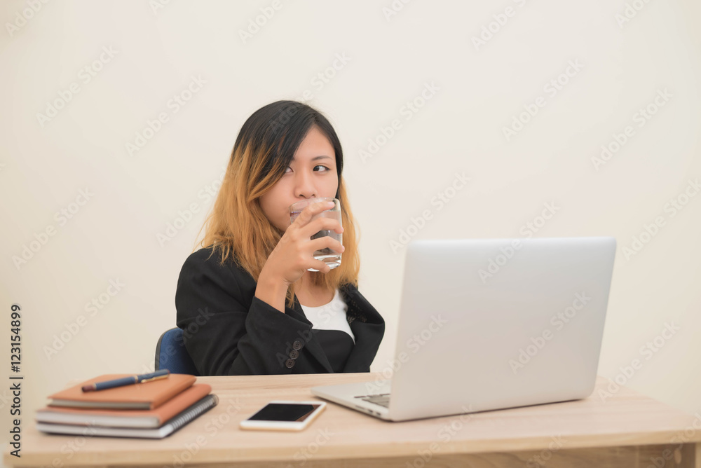 business woman working on his laptop and drinking water. business woman working on his laptop and drinking water.