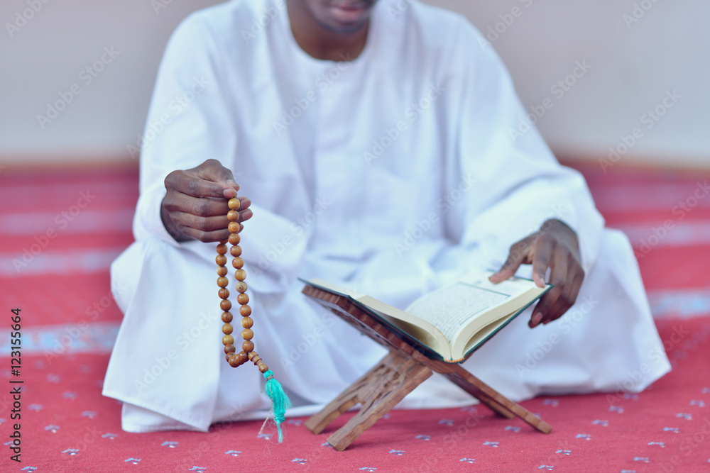 Obraz premium African Muslim Man Making Traditional Prayer To God While Wearing A Traditional Cap Dishdasha