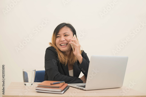 young business woman sitting at workplace and telephone conversa