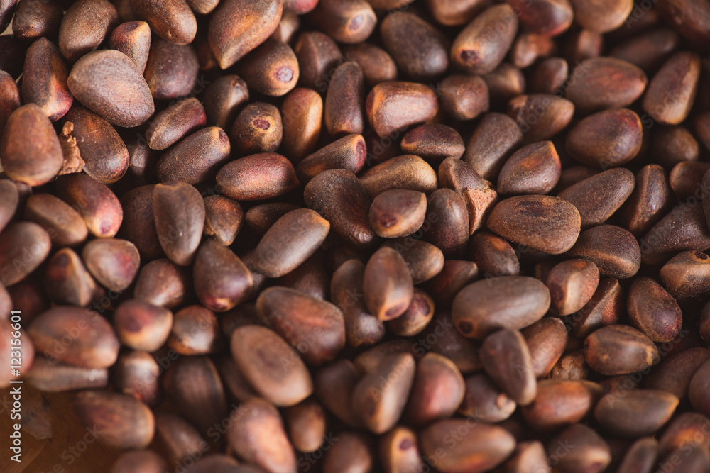 Pine nuts in shells of ciberian cedar as a background. Macro Pine nuts in shells of ciberian cedar as a background. Macro