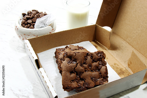 Chocolate chip brownie in a to go box and chocolate chips