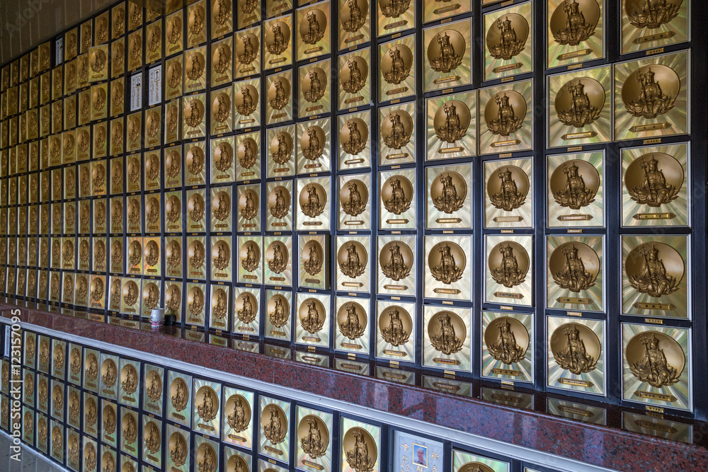 Wall full of gold-framed drawers that contain ashes of the deceased, each with image of a Buddha in the columbarium at the Ten Thousand Buddhas Monastery (Man Fat Tsz) in Sha Tin, Hong Kong, China.