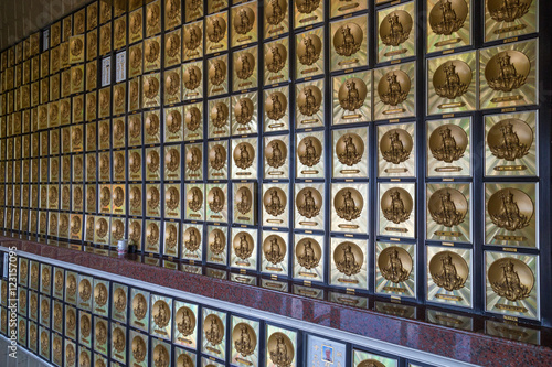 Wall full of gold-framed drawers that contain ashes of the deceased, each with image of a Buddha in the columbarium at the Ten Thousand Buddhas Monastery (Man Fat Tsz) in Sha Tin, Hong Kong, China. photo