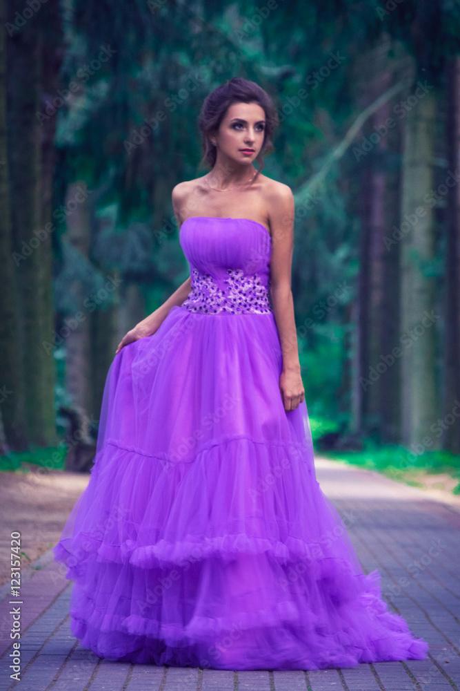 Beautiful girl in violet dress among in the garden Beautiful girl in violet dress among in the garden