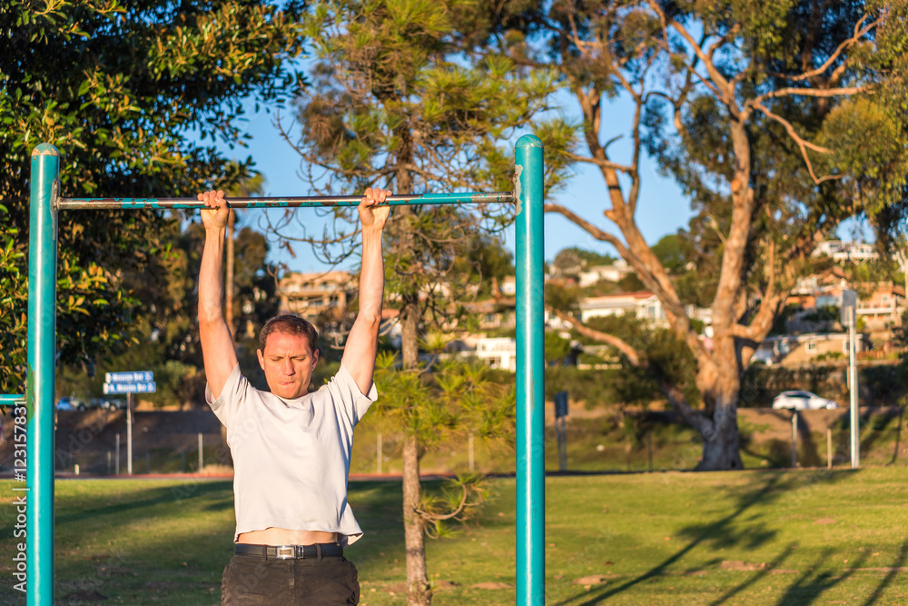 Fit muscular man doing pull ups in outdoor park Fit muscular man doing pull ups in outdoor park