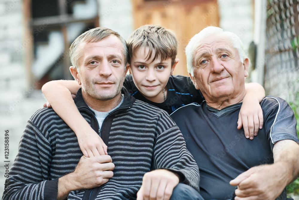 Grandfather with his son and grandson near country house Grandfather with his son and grandson near country house