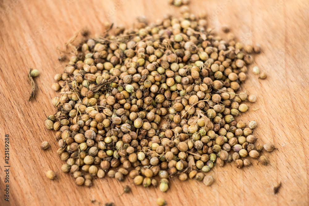 Handful of dryed coriander seeds on wood texture background Handful of dryed coriander seeds on wood texture background