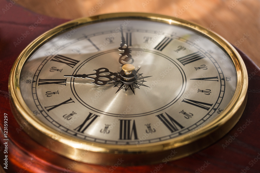 Antique clock with Roman numerals and a beautiful face. Watches are decorated with noble wood Antique clock with Roman numerals and a beautiful face. Watches are decorated with noble wood