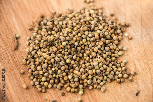 Handful of dryed coriander seeds on wood texture background