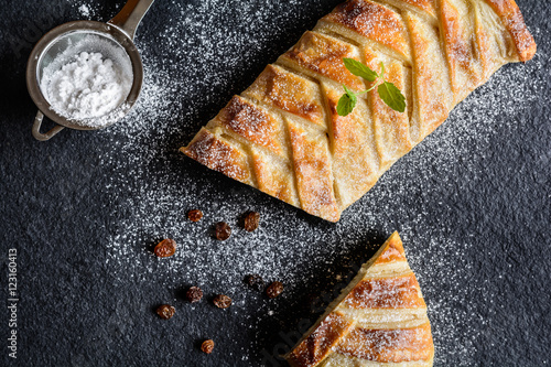Konstfotografi Braided strudel stuffed with curd and raisins, sprinkled with icing sugar