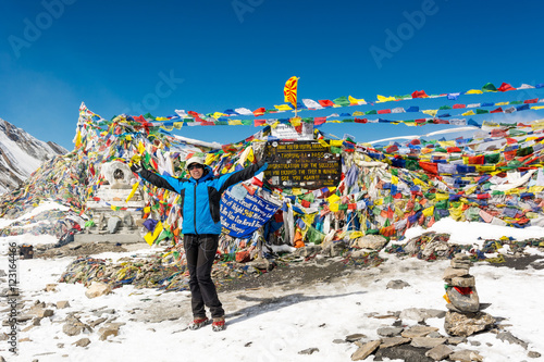 Foto Happy female trekker celebrating ascend to Thorong La pass.