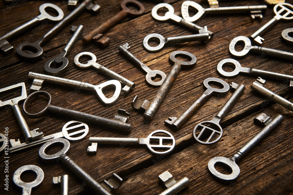many different keys on brown wooden background.
many different keys on brown wooden background.
