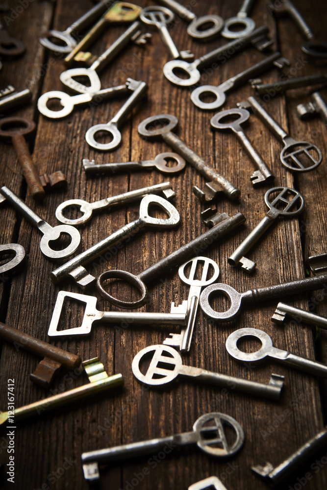many different keys on brown wooden background.
many different keys on brown wooden background.