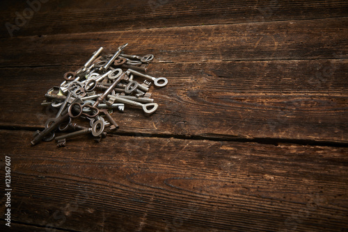 Fototapeta Naklejka Na Ścianę i Meble -  A Pile of Antique Keys on a weathered wooden background
