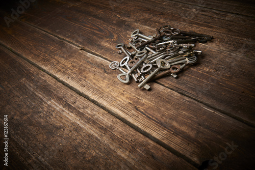 A Pile of Antique Keys on a weathered wooden background 