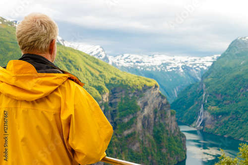 Tourist looking at Geirangerfjord from Flydasjuvet viewpoint Norway