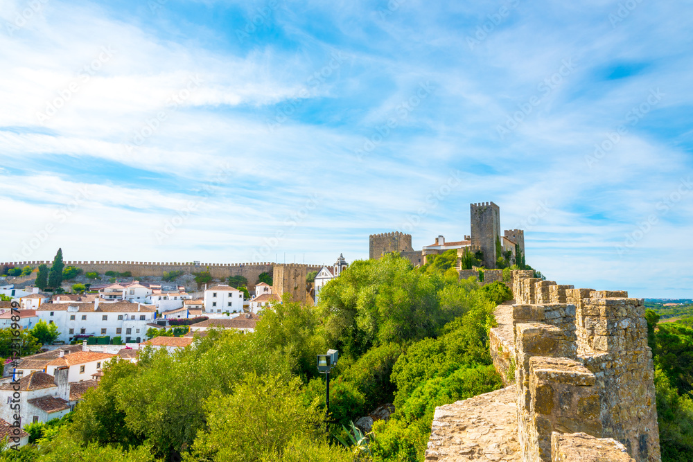 Obidos, Portugal : Cityscape of the town with medieval houses, wall and the Albarra tower. Obidos is a medieval town still inside castle walls, and very popular among tourists.