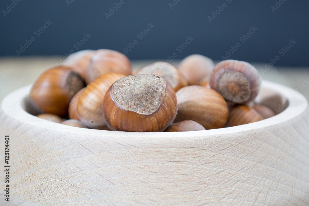 Obraz premium Wooden bowl full of hazzelnuts