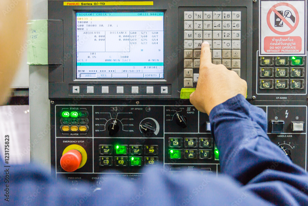 mechanical technician working with Control Panel of CNC machine center at tool workshop mechanical technician working with Control Panel of CNC machine center at tool workshop