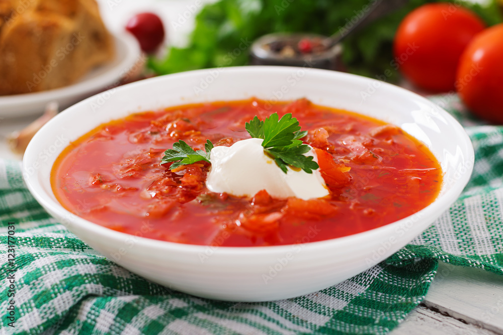 Traditional Ukrainian Russian vegetable borscht on the white wooden background Traditional Ukrainian Russian vegetable borscht on the white wooden background