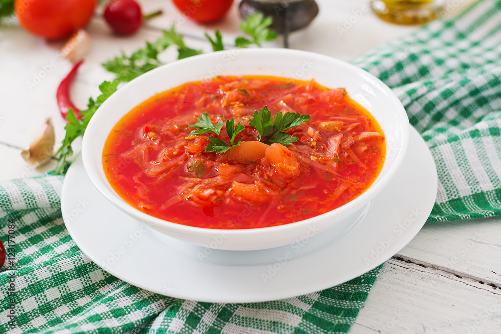 Traditional Ukrainian Russian vegetable borscht on the white wooden background Traditional Ukrainian Russian vegetable borscht on the white wooden background